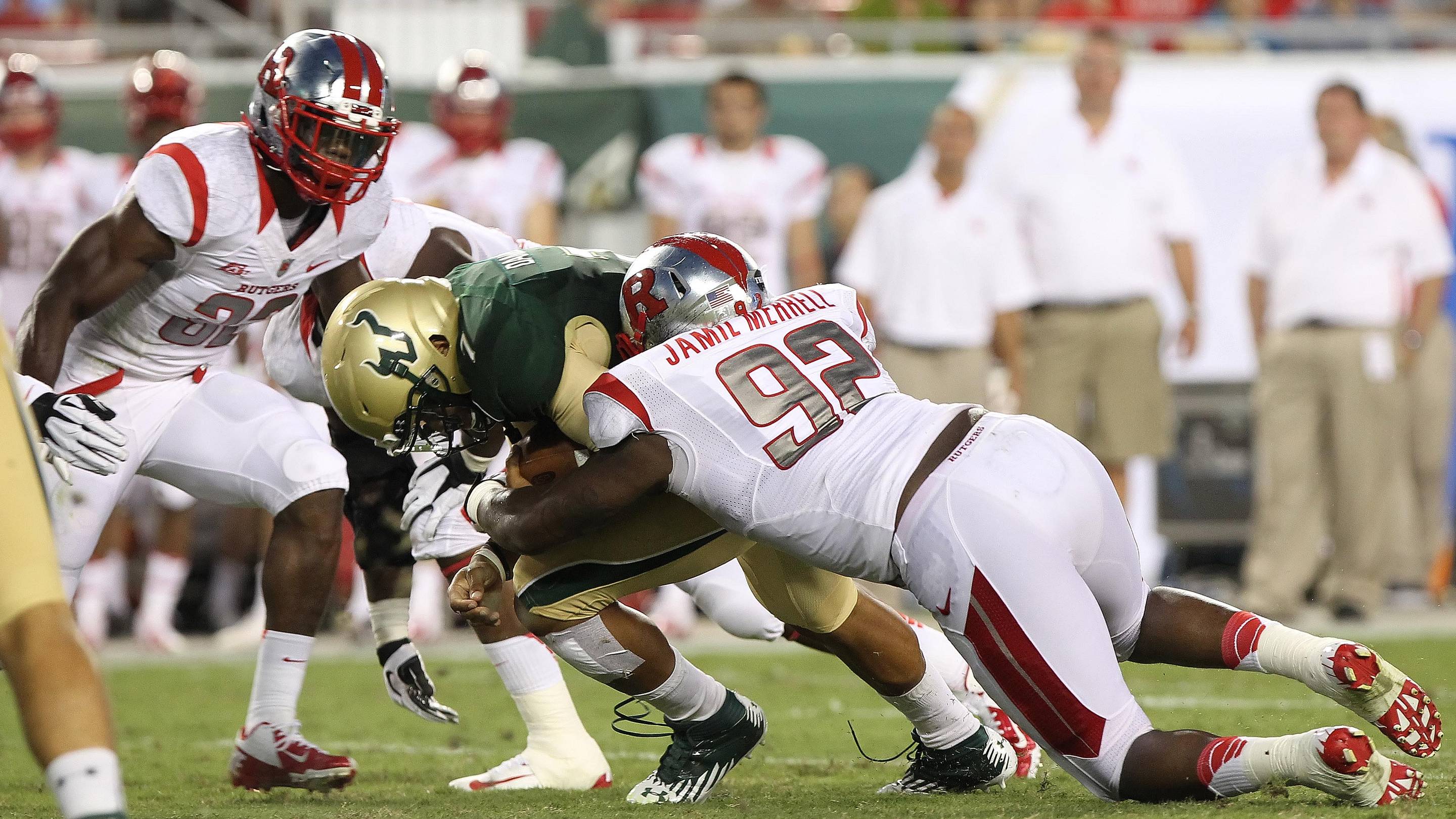 September 13, 2012; Tampa, FL, USA; South Florida Bulls quarterback B.J. Daniels (7) runs with the ball as Rutgers Scarlet Knights defensive lineman Jamil Merrell (92) tackles during the first quarter at Raymond James Stadium. Mandatory Credit: Kim Klement-USA TODAY Sports