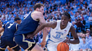 Nov 18, 2025; Chapel Hill, North Carolina, USA; North Carolina Tar Heels forward Caleb Wilson (8) drives on Navy Midshipmen center Aidan Kehoe (99) during the second half at Dean E. Smith Center. 