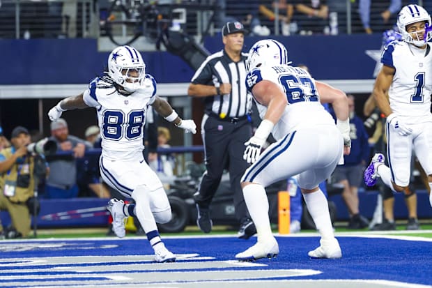 Dallas Cowboys WR CeeDee Lamb celebrates with center Brock Hoffman after scoring a touchdown.