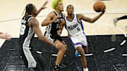 Dec 6, 2024; San Antonio, Texas, USA; Sacramento Kings guard De'Aaron Fox (5) drives to the basket against San Antonio Spurs center Charles Bassey (28) and forward Jeremy Sochan (10) during the first half at Frost Bank Center. Mandatory Credit: Scott Wachter-Imagn Images