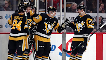 Dec 23, 2024; Pittsburgh, Pennsylvania, USA;  Pittsburgh Penguins center Sidney Crosby (87) celebrates his empty net goal with teammates including defenseman Matt Grzelcyk (24) and defenseman Erik Karlsson (65) against the Philadelphia Flyers during the third period at PPG Paints Arena. Mandatory Credit: Charles LeClaire-Imagn Images