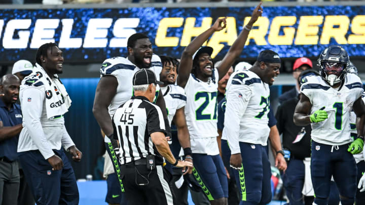 Aug 10, 2024; Inglewood, California, USA; Seattle Seahawks cornerback Riq Woolen (27) and other teammates react from the sidelines after a play against the Los Angeles Chargers during the fourth quarter at SoFi Stadium.