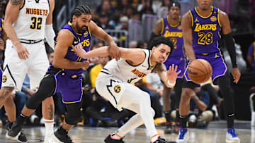 Feb 22, 2025; Denver, Colorado, USA; Los Angeles Lakers guard Gabe Vincent (7) knocks the ball away from Denver Nuggets guard Julian Strawther (3) during the second half at Ball Arena. Mandatory Credit: Christopher Hanewinckel-Imagn Images