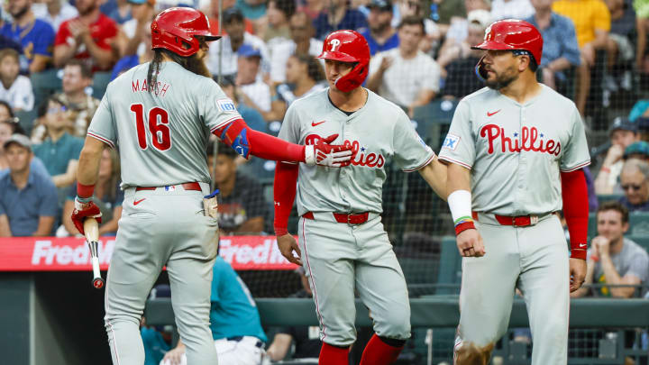 Aug 3, 2024; Seattle, Washington, USA; Philadelphia Phillies center fielder Brandon Marsh (16) greets designated hitter Kyle Schwarber (12, right) and left fielder Austin Hays (9) after a run each by Hays and Schwarber against the Seattle Mariners during the fifth inning at T-Mobile Park