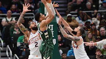 Apr 1, 2025; Milwaukee, Wisconsin, USA;  Milwaukee Bucks forward Giannis Antetokounmpo (34) takes a shot against Phoenix Suns center Nick Richards (2) and  forward Cody Martin (17) in the second quarter at Fiserv Forum. Mandatory Credit: Benny Sieu-Imagn Images