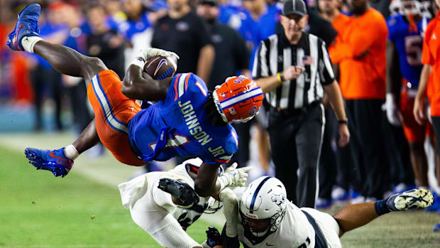 Florida Gators running back Montrell Johnson Jr. is upend by two Samford defenders.