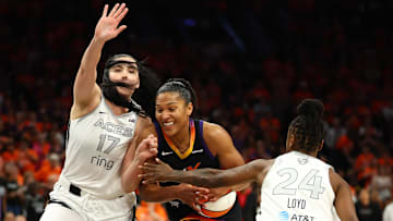Oct 8, 2025; Phoenix, Arizona, USA;Phoenix Mercury forward Alyssa Thomas (25) dribbles past Las Vegas Aces center Megan Gustafson (17) and guard Jewell Loyd (24) in the second half during game three of the 2025 WNBA Finals at PHX Arena. Mandatory Credit: Mark J. Rebilas-Imagn Images