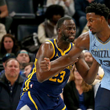 Feb 2, 2024; Memphis, Tennessee, USA; Memphis Grizzlies forward-center Jaren Jackson Jr. (13) dribbles as Golden State Warriors forward Draymond Green (23) defends during the second half at FedExForum. Mandatory Credit: Petre Thomas-Imagn Images