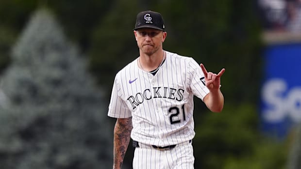 Colorado Rockies starting pitcher Kyle Freeland holds up two fingers while wearing a white jersey and black hat