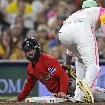 Aug 8, 2025; San Diego, California, USA; Boston Red Sox catcher Connor Wong (12) slides into third base ahead of the tag of San Diego Padres third baseman Manny Machado (13) during the fifth inning at Petco Park. Mandatory Credit: Denis Poroy-Imagn Images