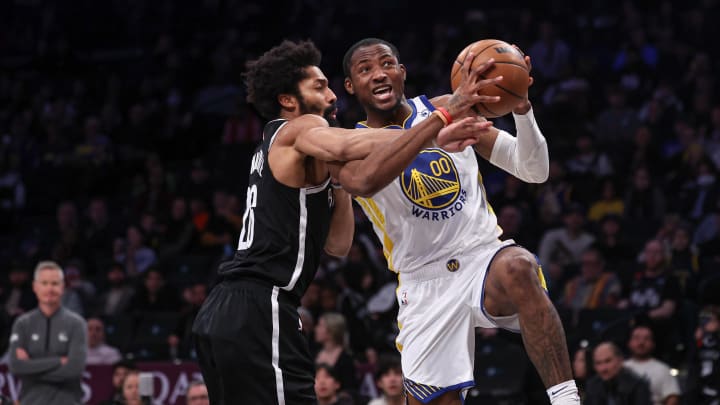 Feb 5, 2024; Brooklyn, New York, USA; Golden State Warriors forward Jonathan Kuminga (00) is fouled by Brooklyn Nets guard Spencer Dinwiddie (26) during the second half at Barclays Center. Mandatory Credit: Vincent Carchietta-USA TODAY Sports