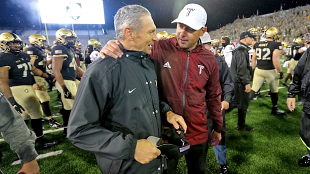 Army Black Knights head coach Jeff Monken greets Troy Trojans head coach Jon Sumrall.