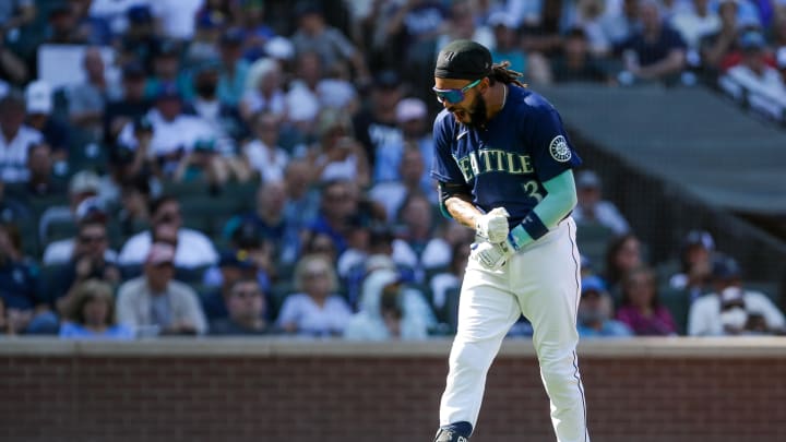 Seattle Mariners shortstop J.P. Crawford (3) throws his batting helmet on the ground after being called out on a third strike and is later ejected by umpire Mark Ripperger (90) against the Washington Nationals during the seventh inning at T-Mobile Park in 2022.