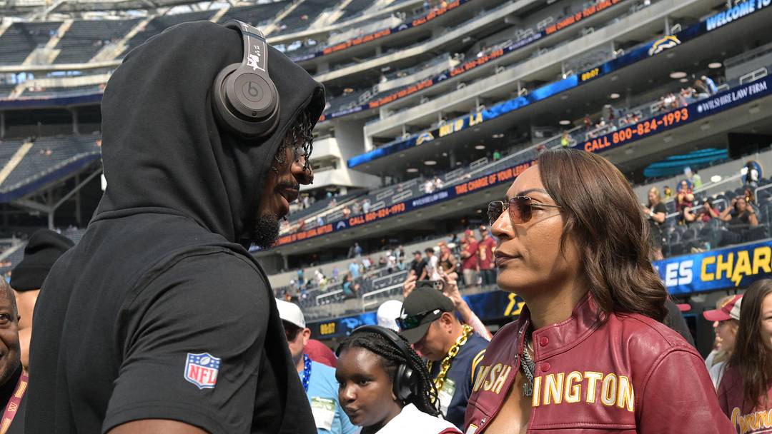 Washington Commanders quarterback Jayden Daniels talks with his mom, Regina Jackson, prior to a game.