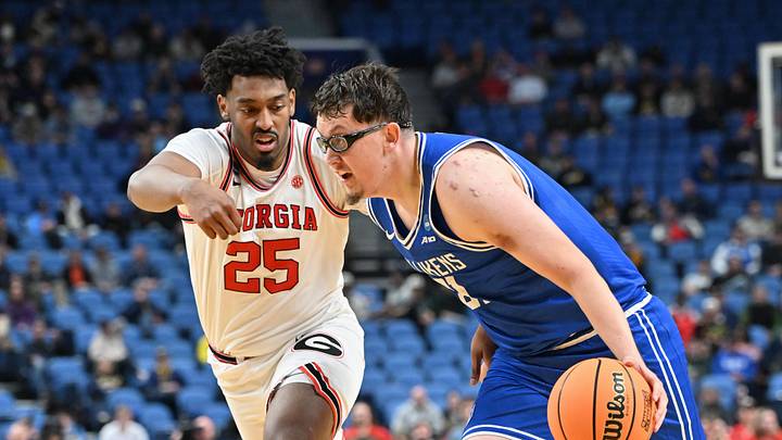Mar 19, 2026; Buffalo, NY, USA; Saint Louis Billikens center Robbie Avila (21) dribbles the ball against Georgia Bulldogs forward Justin Abson (25) during the second half of a first round game of the men's 2026 NCAA Tournament at Keybank Center. Mandatory Credit: Mark Konezny-Imagn Images
