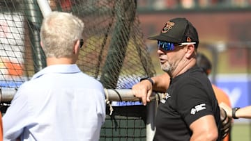 Former  Baltimore Orioles manager Brandon Hyde (18) talks with General manager Mike Elias (left) during batting practice prior to a 2022 game between the Orioles and the New York Yankees at Oriole Park at Camden Yards.