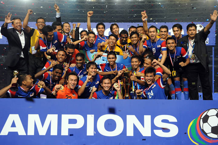 Malaysia's players and officials hold th