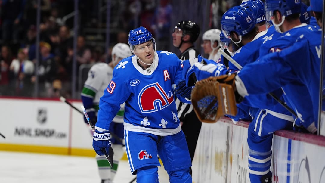 Apr 1, 2026; Denver, Colorado, USA; Colorado Avalanche center Nathan MacKinnon (29) (center) celebrates his fiftieth goal of the season with teammates during the first period against the Vancouver Canucks at Ball Arena. Mandatory Credit: Ron Chenoy-Imagn Images