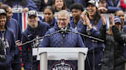 Apr 13, 2025; Hartford, CT, USA;   UConn Huskies head coach Geno Auriemma addresses the crowd while UConn student-athlete Paige Bueckers looks on during the Final Four champions victory parade and rally outside of the XL Center in Hartford, CT. Mandatory Credit: Scott Rausenberger-Imagn Images