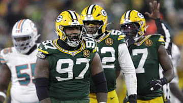 Nov 28, 2024; Green Bay, Wisconsin, USA; Green Bay Packers defensive tackle Kenny Clark (97) celebrates sacking Miami Dolphins quarterback Tua Tagovailoa with defensive end Rashan Gary (52) and linebacker Quay Walker (7) at Lambeau Field. Mandatory Credit: Dan Powers-Imagn Images