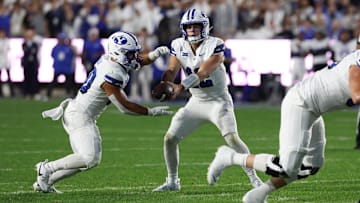 Sep 21, 2024; Provo, Utah, USA; Brigham Young Cougars quarterback Jake Retzlaff (12) hands the ball off to running back Sione I Moa (30) during the second quarter at LaVell Edwards Stadium.
