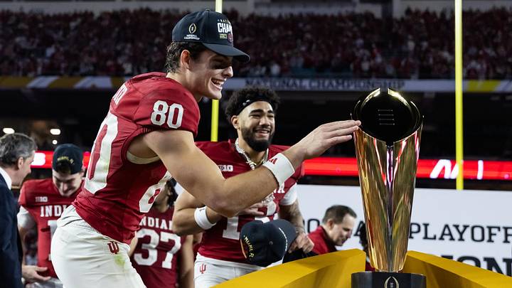 Jan 19, 2026; Miami Gardens, FL, USA; Indiana Hoosiers wide receiver Charlie Becker (80) celebrates with the trophy after defeating the Miami Hurricanes in the College Football Playoff National Championship game at Hard Rock Stadium. Mandatory Credit: Mark J. Rebilas-Imagn Images