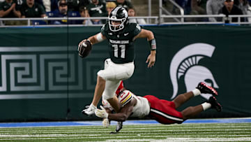 Nov 29, 2025; Detroit, Michigan, USA; Michigan State quarterback Alessio Milivojevic (11) breaks a tackle from Maryland defensive lineman Sidney Stewart (29) in the third quarter at Ford Field. Mandatory Credit: Brendan Mullin-Imagn Images