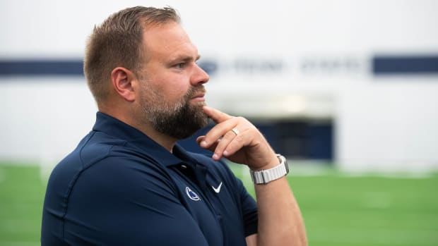 Penn State offensive coordinator Andy Kotelnicki touches his chin as he listens to a question from a reporter.