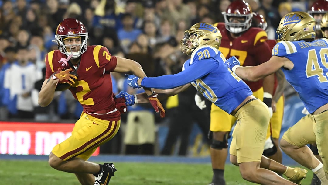 Nov 23, 2024; Pasadena, California, USA; USC Trojans wide receiver Duce Robinson (2) tries to run past UCLA Bruins linebacker Kain Medrano (20) during the second quarter at Rose Bowl. Mandatory Credit: Robert Hanashiro-Imagn Images