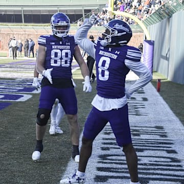 Nov 30, 2024; Chicago, Illinois, USA;  Northwestern Wildcats wide receiver A.J. Henning (8) celebrates after scoring a touchdown against the Illinois Fighting Illini during the second half at Wrigley Field. Mandatory Credit: Matt Marton-Imagn Images
