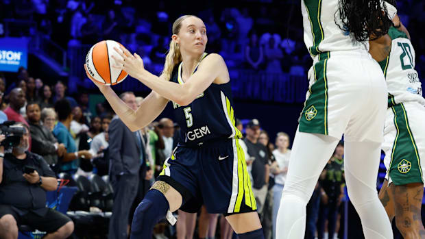 Dallas Wings guard Paige Bueckers looks to pass while wearing a blue uniform with yellow trim. 
