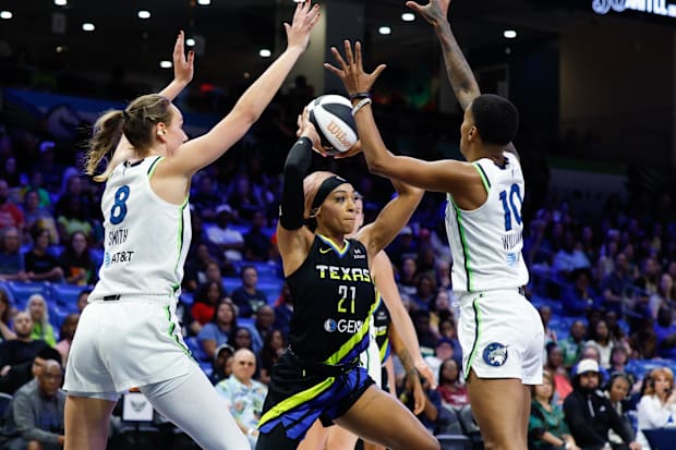 Dallas Wings guard DiJonai Carrington (21) looks to pass between Minnesota Lynx forward Alanna Smith (8)