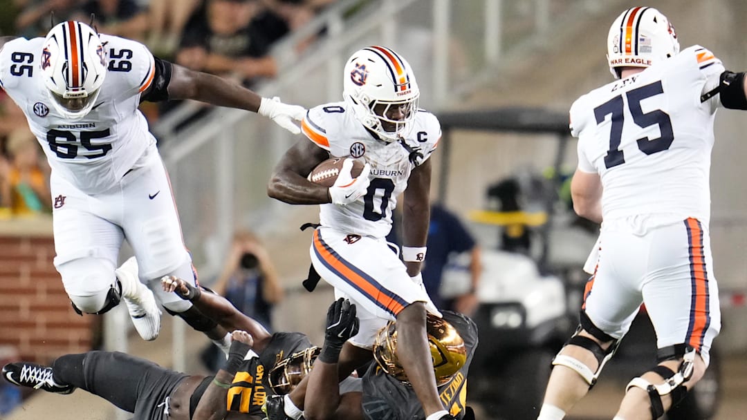 Aug 29, 2025; Waco, Texas, USA;  Auburn Tigers running back Damari Alston (0) runs the ball against Baylor Bears defensive lineman Devonte Tezino (59) during the first half at McLane Stadium. Mandatory Credit: Chris Jones-Imagn Images