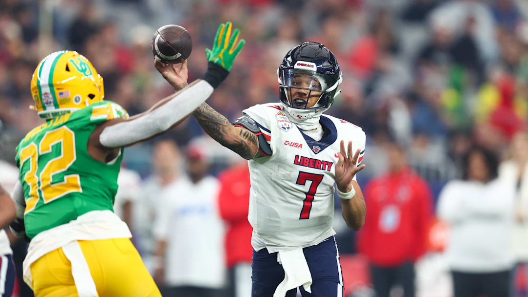 Jan 1, 2024; Glendale, AZ, USA; Liberty Flames quarterback Kaidon Salter (7) throws the ball under pressure from Oregon Ducks linebacker Emar'rion Winston (32) during the second half in the 2024 Fiesta Bowl at State Farm Stadium. Mandatory Credit: Mark J. Rebilas-Imagn Images