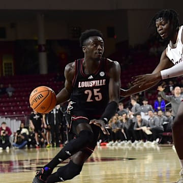 Feb 5, 2025; Chestnut Hill, Massachusetts, USA;  Louisville Cardinals forward Aboubacar Traore (25) controls the ball while Boston College Eagles forward Jayden Hastings (22) defends during the first half at Conte Forum. Mandatory Credit: Bob DeChiara-Imagn Images
