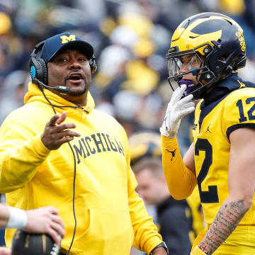 Michigan offensive pass game coordinator and wide receivers coach Ron Bellamy talks to quarterback Davis Warren (16) during the second half of the spring game at Michigan Stadium in Ann Arbor on Saturday, April 20, 2024.