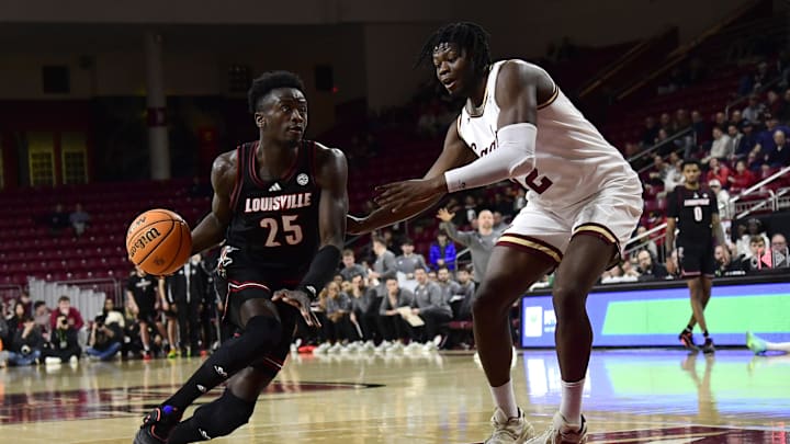 Feb 5, 2025; Chestnut Hill, Massachusetts, USA;  Louisville Cardinals forward Aboubacar Traore (25) controls the ball while Boston College Eagles forward Jayden Hastings (22) defends during the first half at Conte Forum. Mandatory Credit: Bob DeChiara-Imagn Images