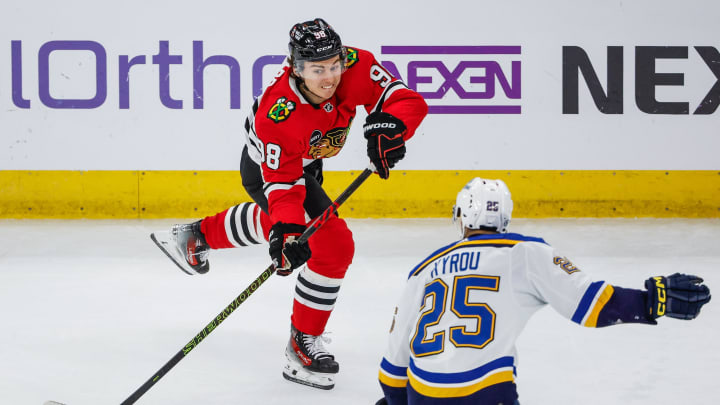 Nov 26, 2023; Chicago, Illinois, USA; Chicago Blackhawks center Connor Bedard (98) plays the puck against St. Louis Blues center Jordan Kyrou (25) during the second period at United Center. Mandatory Credit: Kamil Krzaczynski-USA TODAY Sports