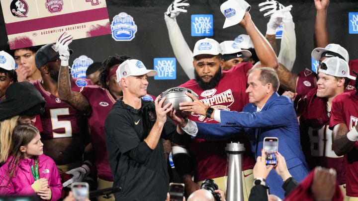 Dec 2, 2023; Charlotte, NC, USA; Florida State Seminoles head coach Mike Norvell is handed the ACC Championship trophy after the game against the Louisville Cardinals at Bank of America Stadium. Mandatory Credit:  Jim Dedmon-USA TODAY Sports