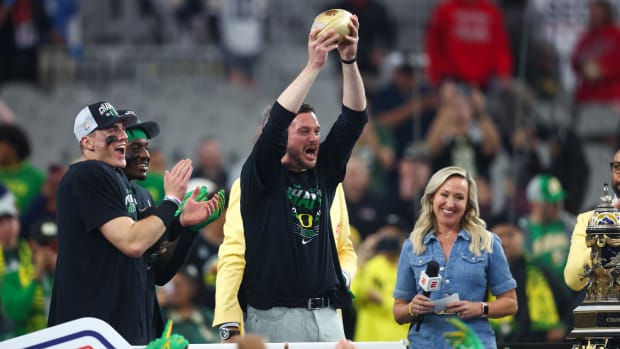 Oregon Ducks head coach Dan Lanning lifts the Fiesta Bowl trophy after a victory against the Liberty Flames 