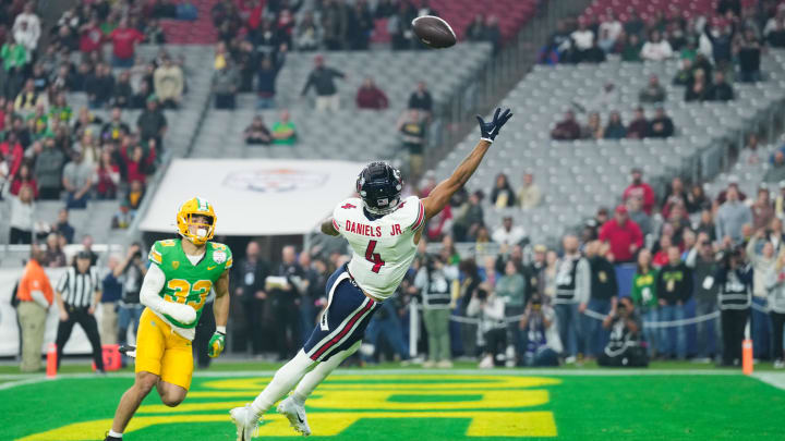 Jan 1, 2024; Glendale, AZ, USA; Liberty Flames wide receiver CJ Daniels (4) attempts to catch a pass as Oregon Ducks defensive back Evan Williams (33) defends him in the first quarter of the 2024 Fiesta Bowl at State Farm Stadium. Mandatory Credit: Joe Camporeale-USA TODAY Sports