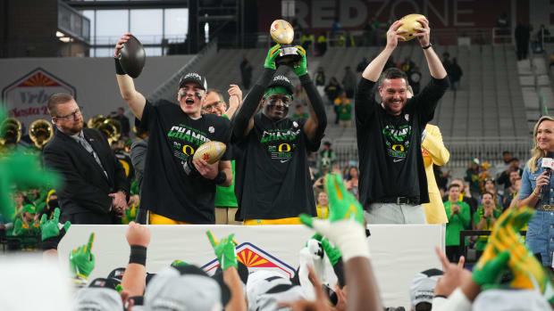 Oregon Ducks quarterback Bo Nix (10), linebacker Jeffrey Bassa (2) and  head coach Dan Lanning lift the offensive MVP, defens