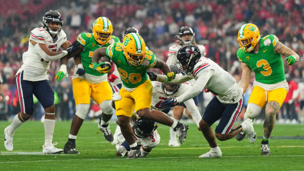 Oregon Ducks running back Jordan James breaks a tackle by Liberty Flames cornerback Kobe Singleton.