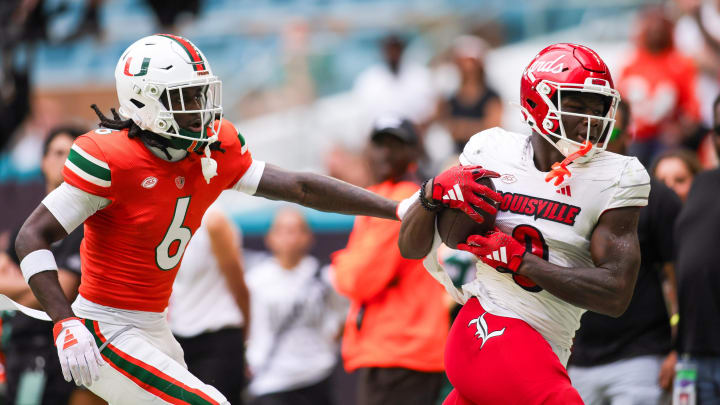 Nov 18, 2023; Miami Gardens, Florida, USA; Louisville Cardinals wide receiver Chris Bell (0) catches the football against Miami Hurricanes defensive back Damari Brown (6) during the second quarter at Hard Rock Stadium.