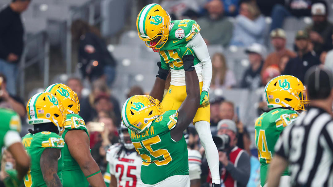 Jan 1, 2024; Glendale, AZ, USA; Oregon Ducks wide receiver Tez Johnson (15) celebrates scoring a touchdown with offensive lineman Marcus Harper II (55) during the second half against the Liberty Flames in the 2024 Fiesta Bowl at State Farm Stadium. Mandatory Credit: Mark J. Rebilas-USA TODAY Sports