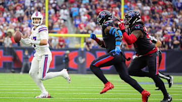Josh Allen runs away from a pair of Houston Texans defenders