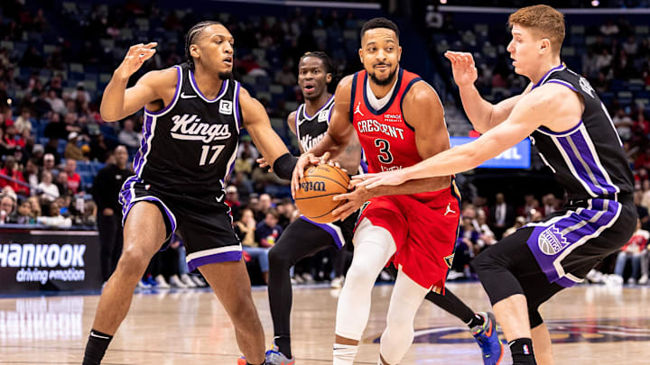 Dec 12, 2024; New Orleans, Louisiana, USA; Sacramento Kings guard Kevin Huerter (9) and center Isaac Jones (17) defend New Orleans Pelicans guard CJ McCollum (3) during the first half at Smoothie King Center. Mandatory Credit: Stephen Lew-Imagn Images