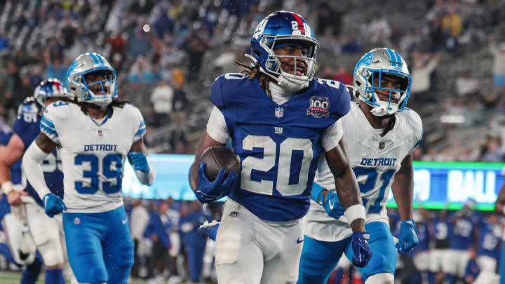 Aug 8, 2024; East Rutherford, New Jersey, USA; New York Giants running back Eric Gray (20) scores a rushing touchdown in front of Detroit Lions cornerback Amik Robertson (21) and cornerback Morice Norris (39) during the first half at MetLife Stadium. Mandatory Credit: Vincent Carchietta-USA TODAY Sports