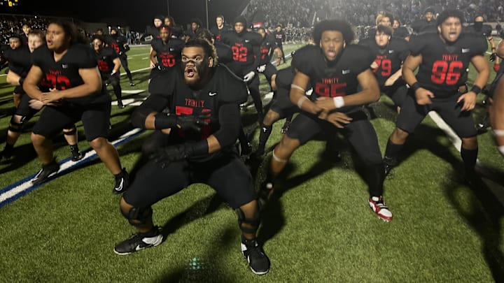 Euless Trinity football players do a ceremonial dance before a Texas high school football game. 