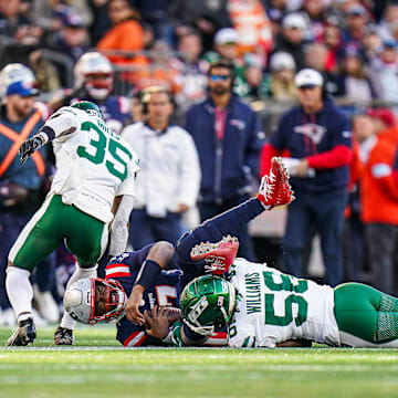 Oct 27, 2024; Foxborough, Massachusetts, USA; New England Patriots quarterback Jacoby Brissett (7) runs the ball against New York Jets linebacker Quincy Williams (56) in the second half  at Gillette Stadium. Mandatory Credit: David Butler II-Imagn Images
